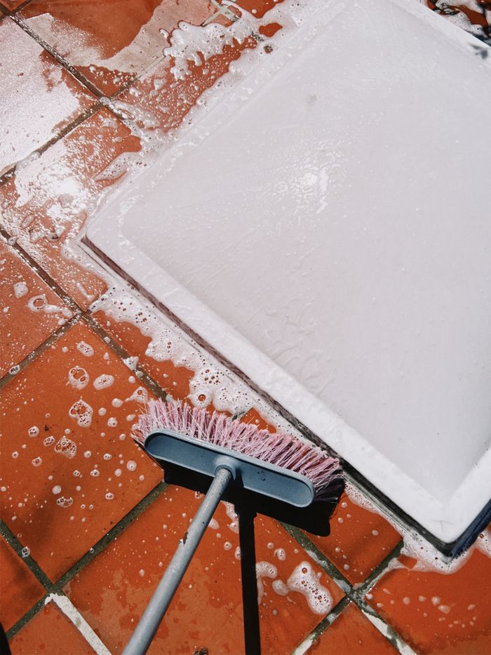 hero-01 Close-up of soapy tiles being scrubbed. Perfect for cleaning and maintenance themes.